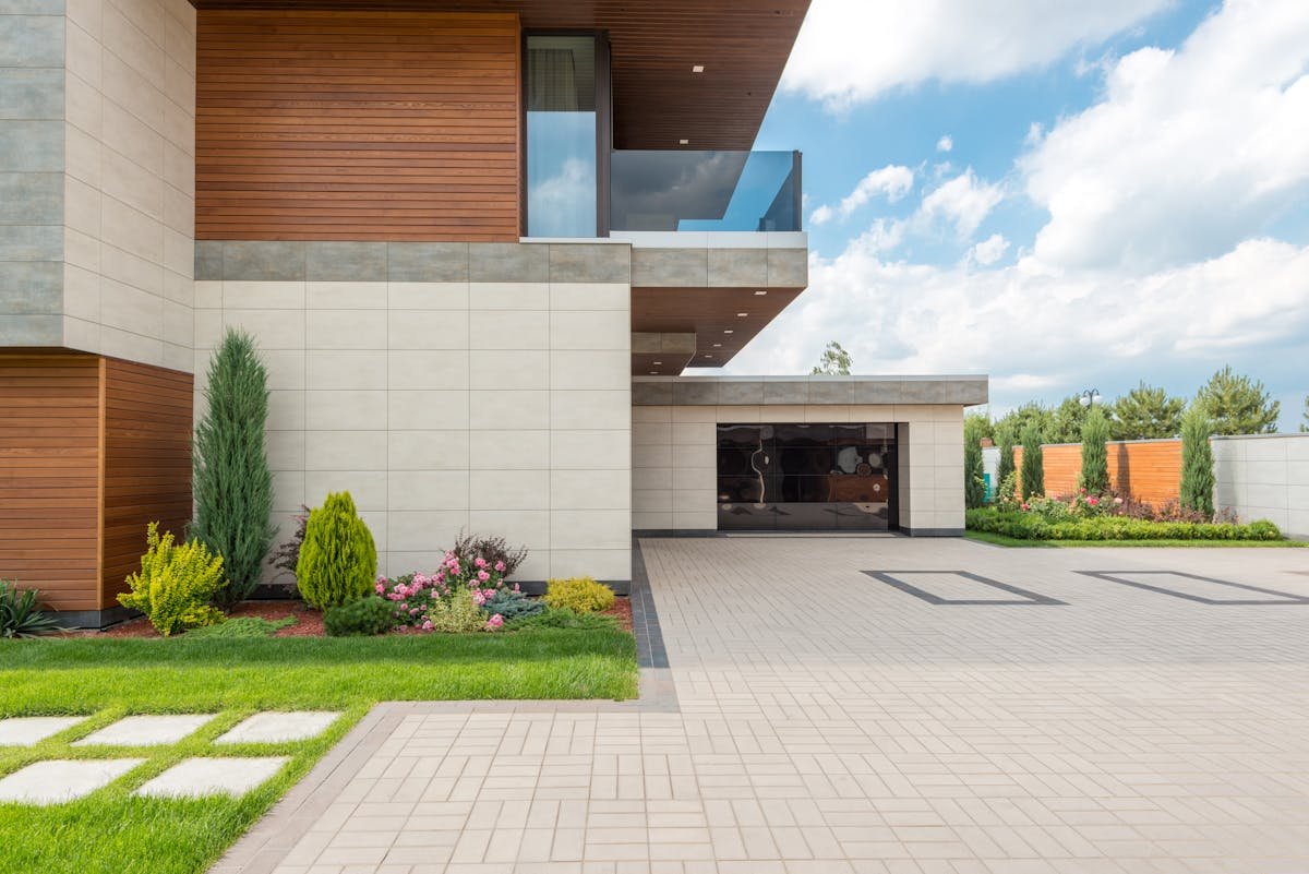 Brand-new residential concrete driveway with broom finish in a Houston, TX neighborhood at golden hour